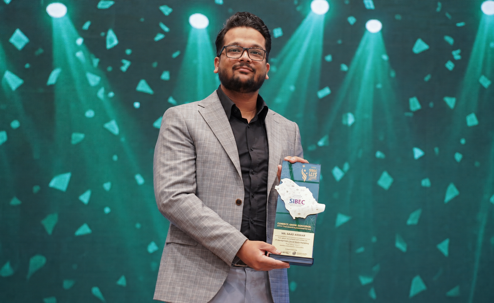 Saad Anwar holding his SIBEC international business recognition award